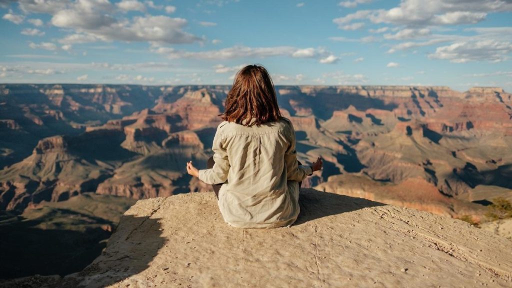 mujer meditando en un acantilado